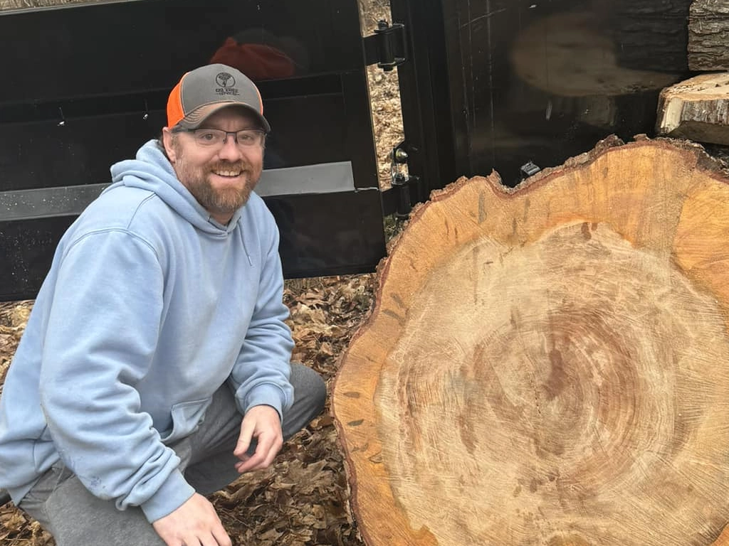 Ryan kneeling next to tree cross section