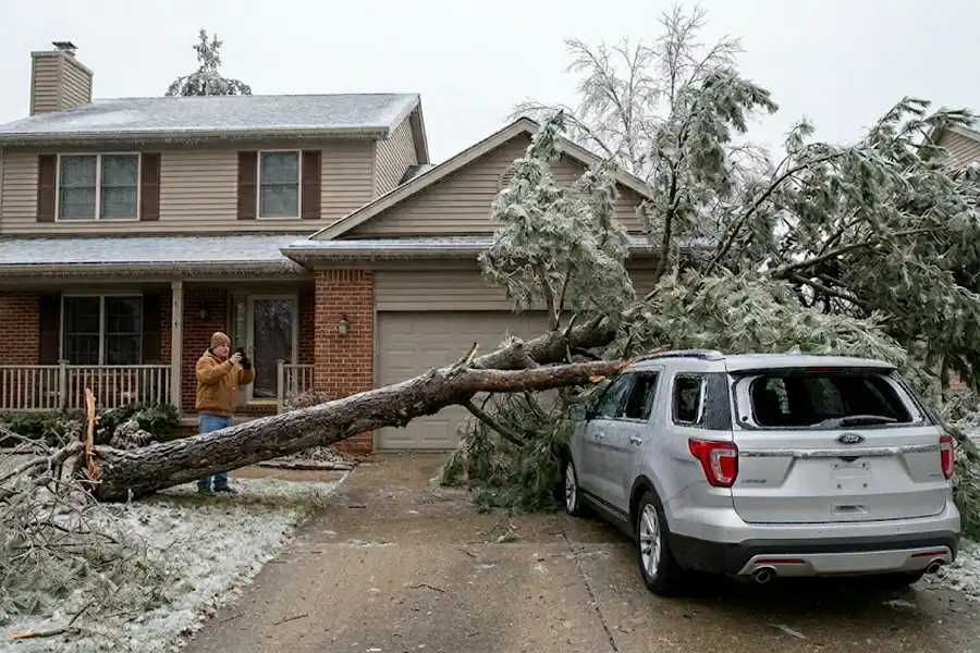 Homeowner taking photos documenting damage of ice storm on vehicle